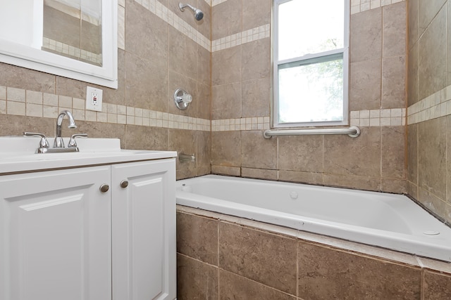 bathroom with tile walls, vanity, and tiled shower / bath