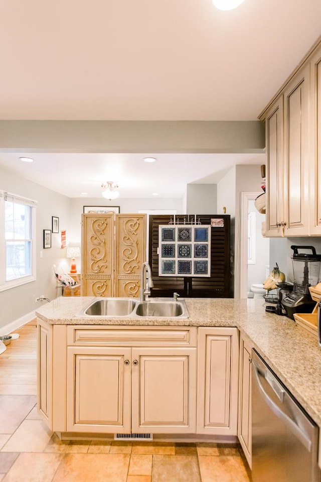 kitchen with dishwasher, sink, kitchen peninsula, light brown cabinetry, and light tile patterned floors