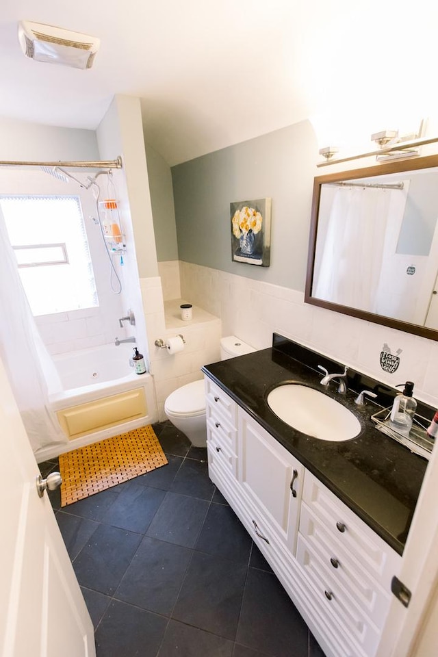 full bathroom with tile patterned floors, vanity, shower / bath combo with shower curtain, tile walls, and toilet