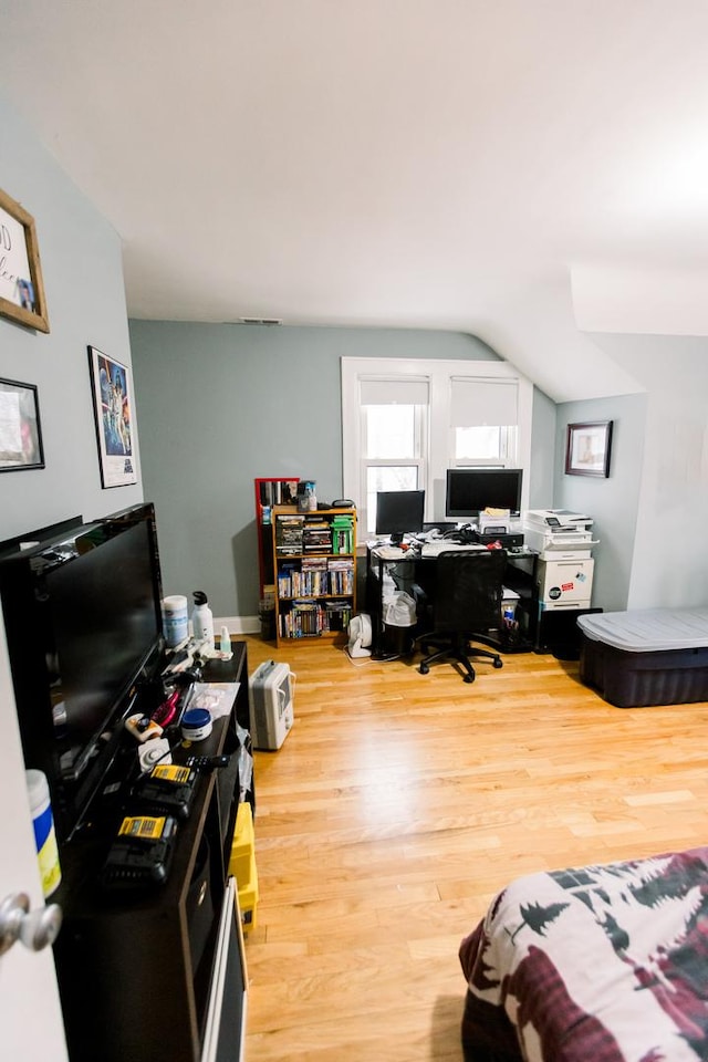 home office featuring light hardwood / wood-style floors and vaulted ceiling