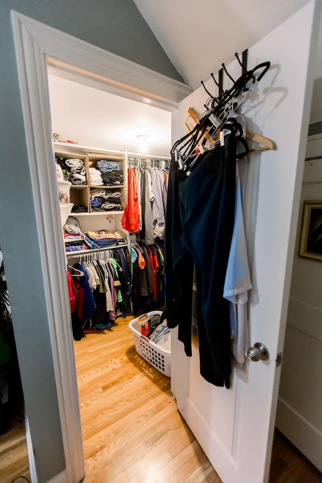 walk in closet with hardwood / wood-style floors and lofted ceiling