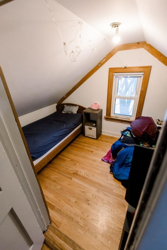 bedroom featuring hardwood / wood-style floors and vaulted ceiling