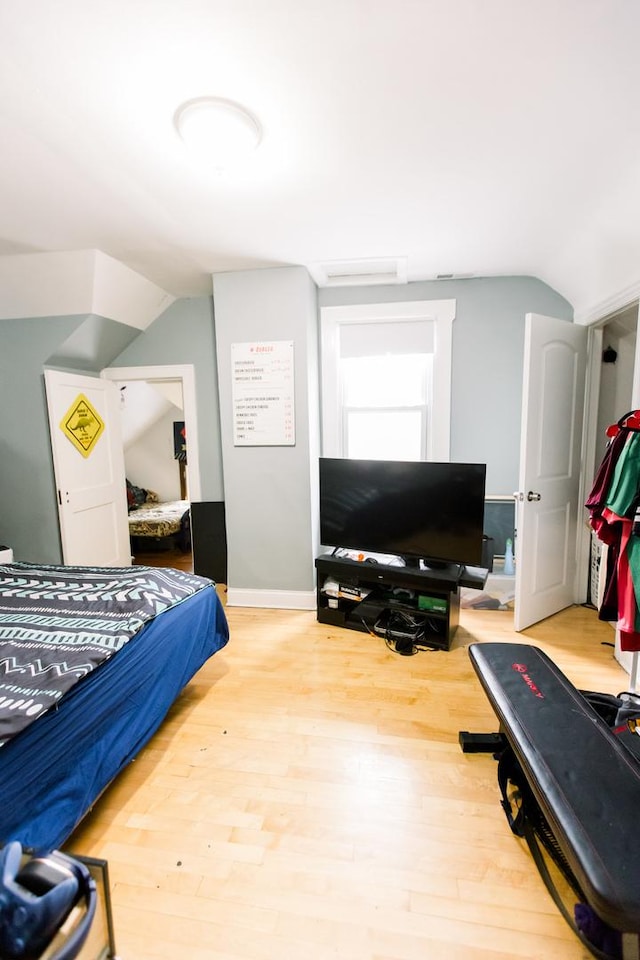 bedroom with hardwood / wood-style flooring and lofted ceiling