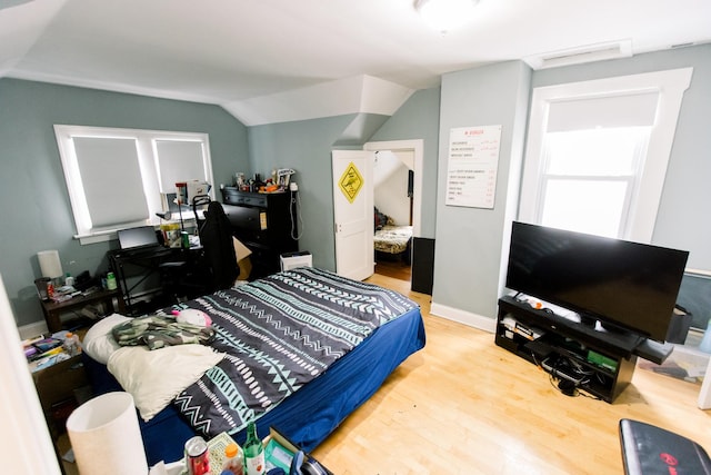 bedroom featuring hardwood / wood-style flooring and vaulted ceiling