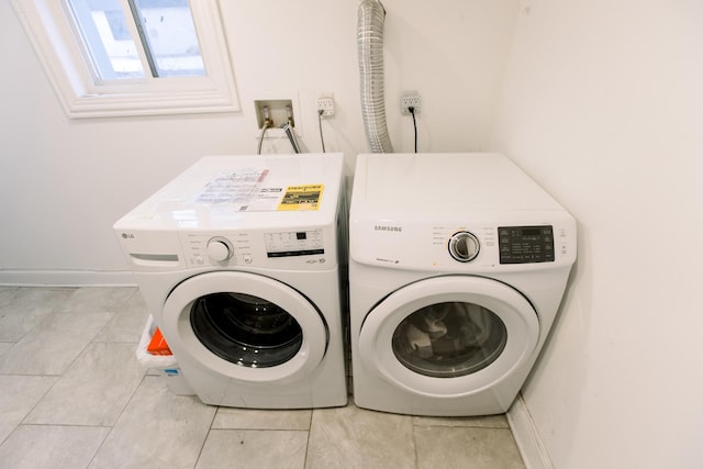 laundry room featuring washer and dryer and light tile patterned flooring