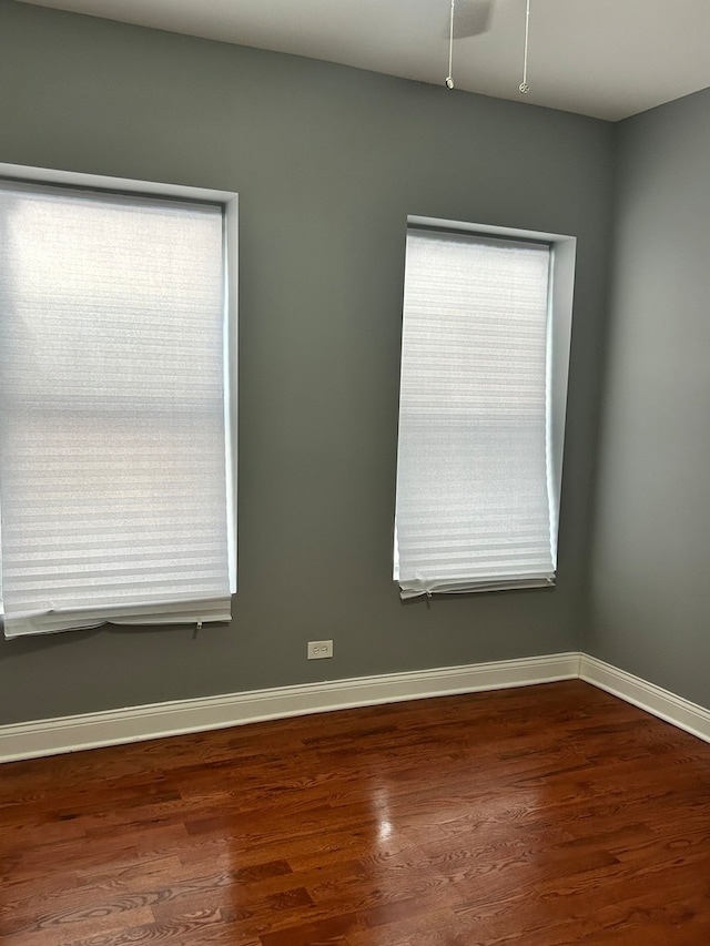 unfurnished room with a healthy amount of sunlight and dark hardwood / wood-style floors