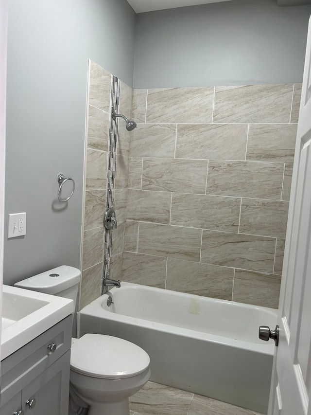 full bathroom with tile flooring, vanity, tiled shower / bath combo, and toilet