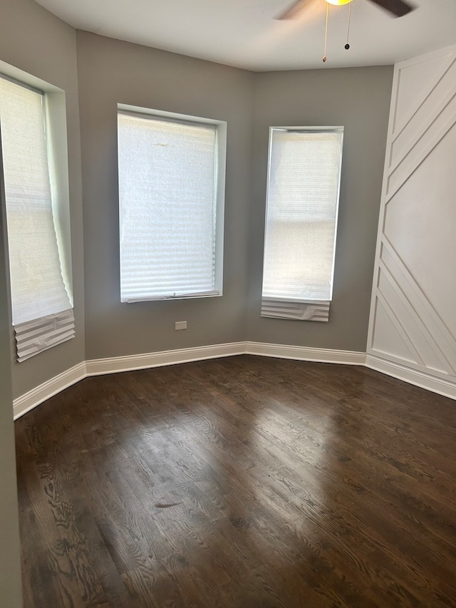 empty room featuring ceiling fan and dark hardwood / wood-style flooring