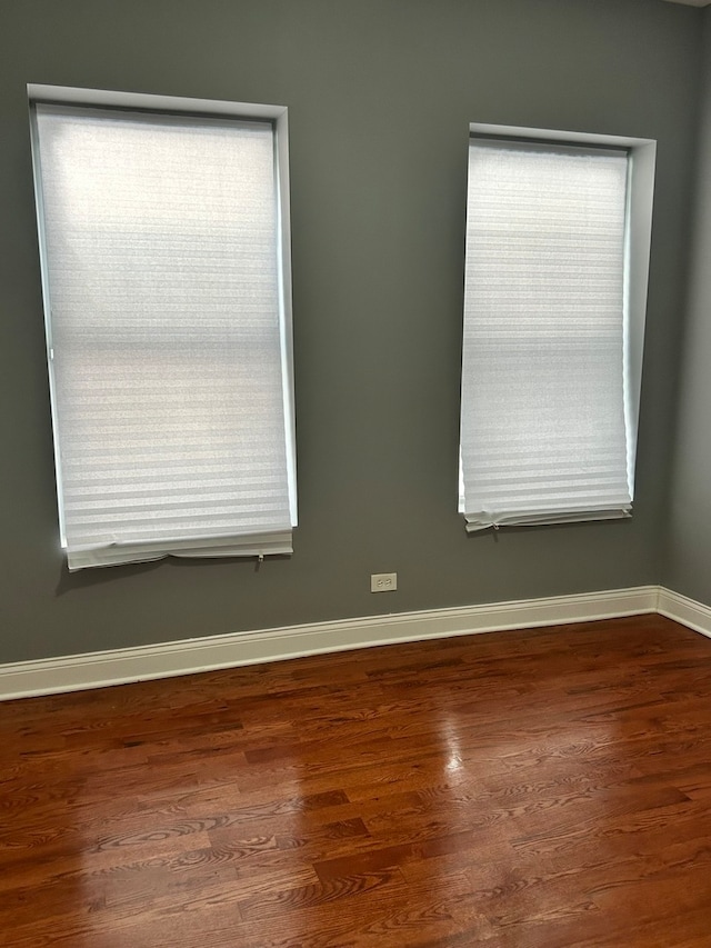 empty room with plenty of natural light and dark hardwood / wood-style floors