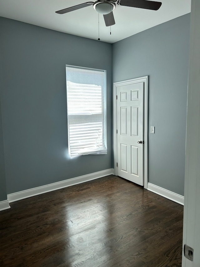 empty room with ceiling fan and dark wood-type flooring