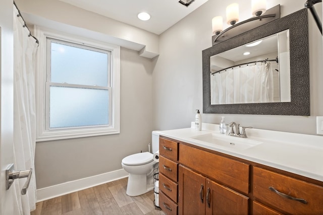 bathroom with vanity, wood-type flooring, and toilet