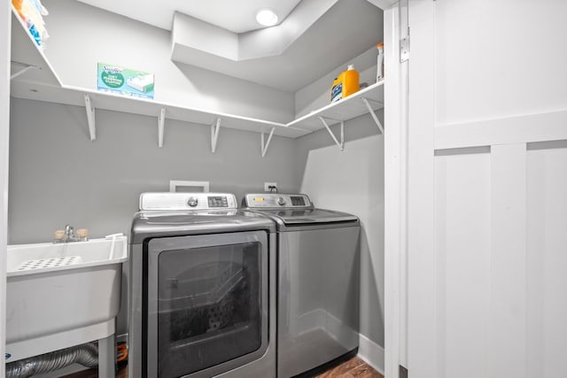 laundry room with hardwood / wood-style floors, sink, and separate washer and dryer