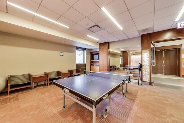 recreation room with a drop ceiling and light colored carpet