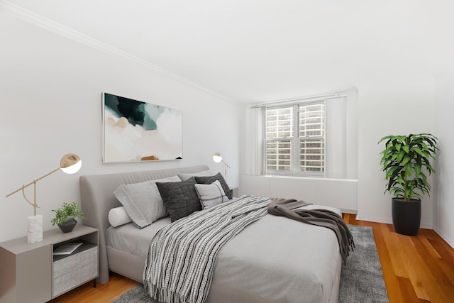 bedroom featuring ornamental molding and hardwood / wood-style floors