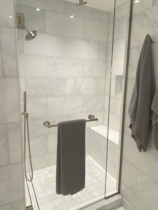 bathroom with tile patterned flooring, tile walls, vanity, and tiled bath