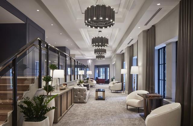 living room featuring a raised ceiling, a premium fireplace, and crown molding