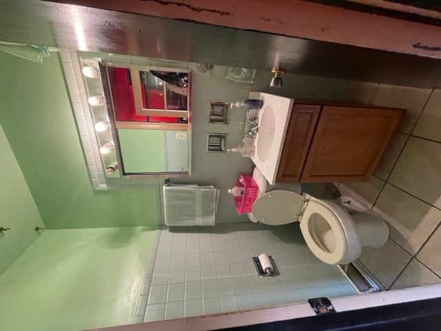 bathroom with toilet and tile floors