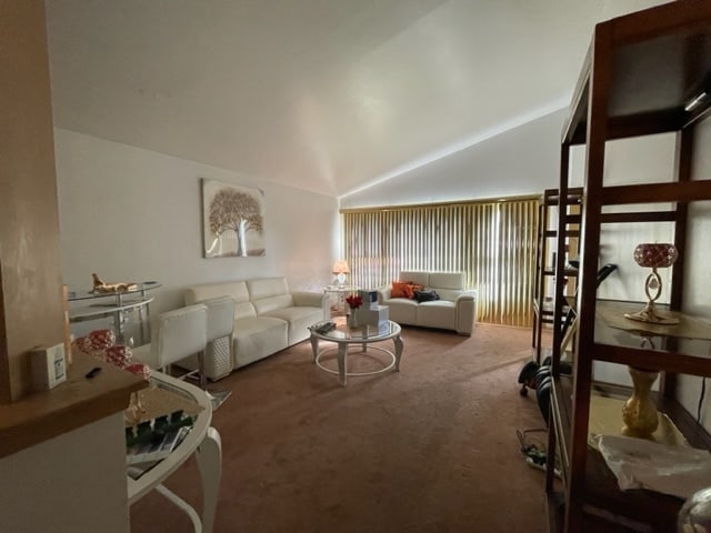 carpeted living room with lofted ceiling