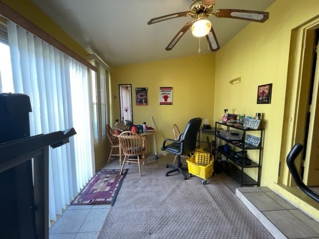 home office featuring lofted ceiling, plenty of natural light, carpet flooring, and ceiling fan