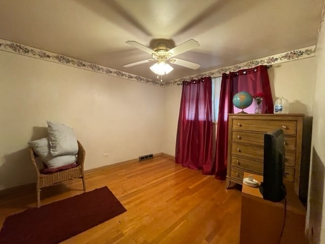 sitting room featuring hardwood / wood-style floors and ceiling fan