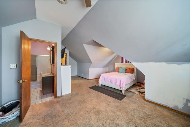 carpeted bedroom with ensuite bathroom, ceiling fan, and vaulted ceiling