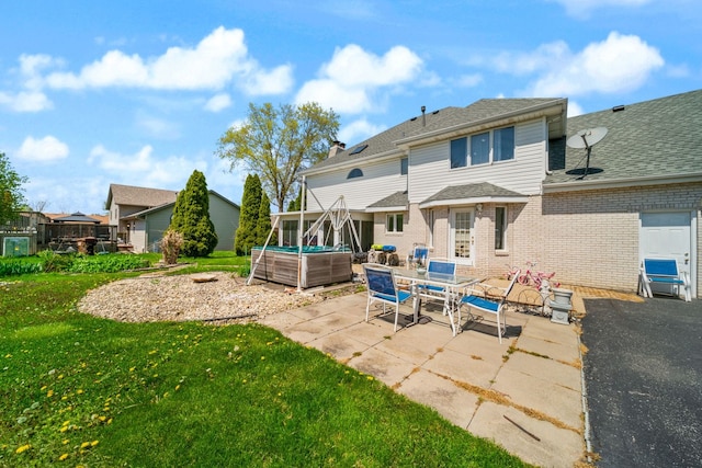 back of house featuring a patio and a yard