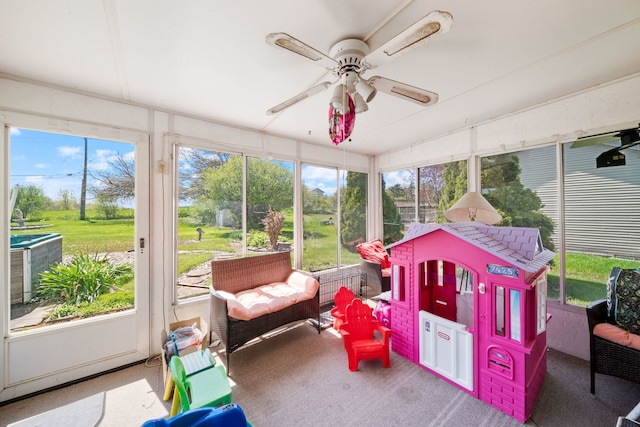 sunroom / solarium featuring ceiling fan