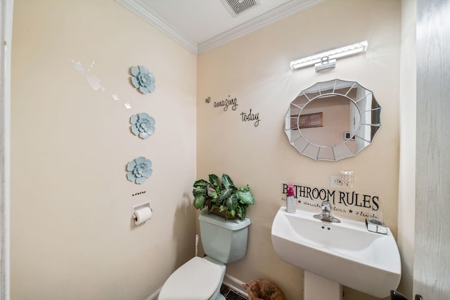 bathroom featuring sink, ornamental molding, and toilet