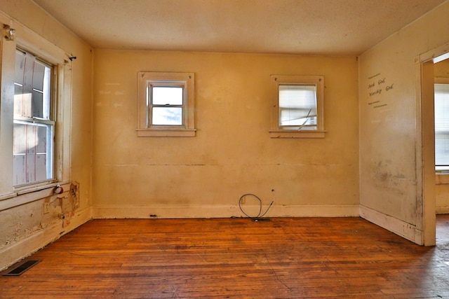 spare room featuring hardwood / wood-style floors and plenty of natural light