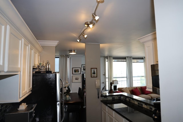 kitchen featuring black fridge, rail lighting, white cabinetry, and crown molding