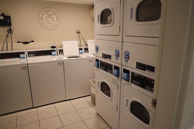 laundry room with stacked washer / drying machine, light tile patterned flooring, and washing machine and clothes dryer