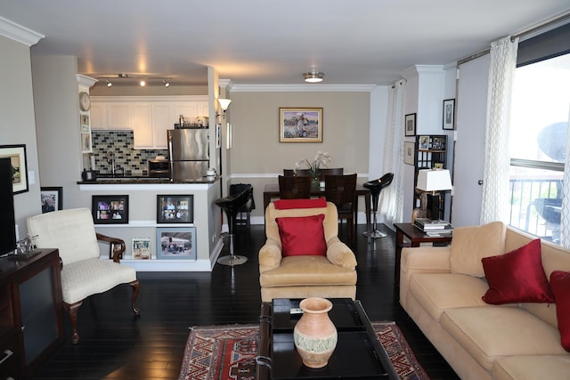 living room with dark wood-type flooring and ornamental molding