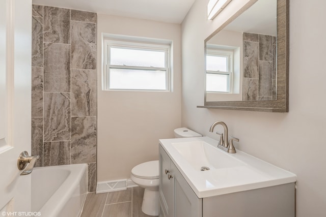 full bathroom featuring vanity, tile floors, toilet, and tiled shower / bath