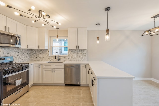 kitchen featuring white cabinets, sink, decorative light fixtures, stainless steel appliances, and kitchen peninsula