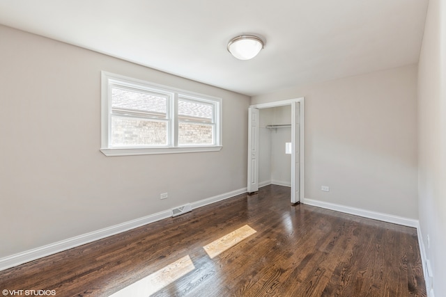 unfurnished bedroom featuring a closet and dark hardwood / wood-style floors