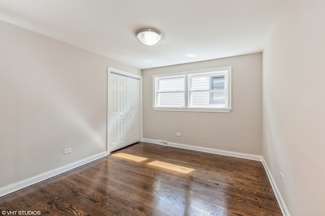 unfurnished bedroom featuring wood-type flooring and a closet