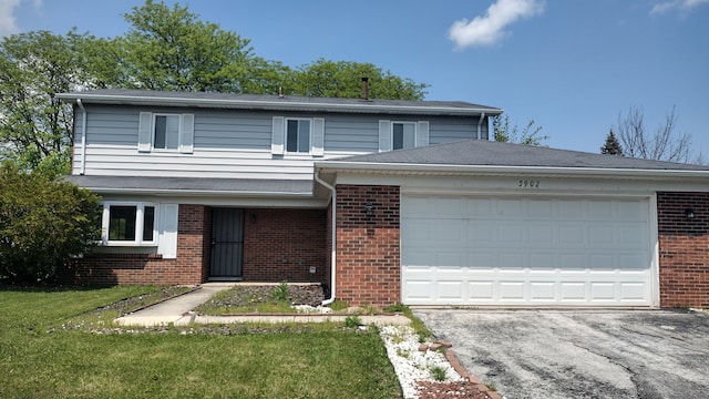 view of front property featuring a garage and a front lawn