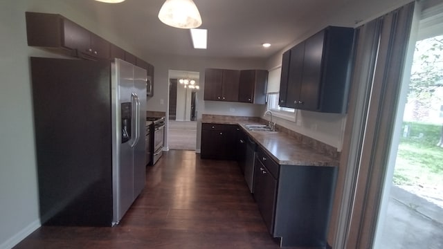 kitchen with appliances with stainless steel finishes, sink, dark hardwood / wood-style flooring, and a healthy amount of sunlight