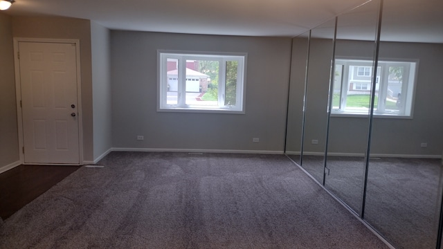 unfurnished bedroom with dark carpet