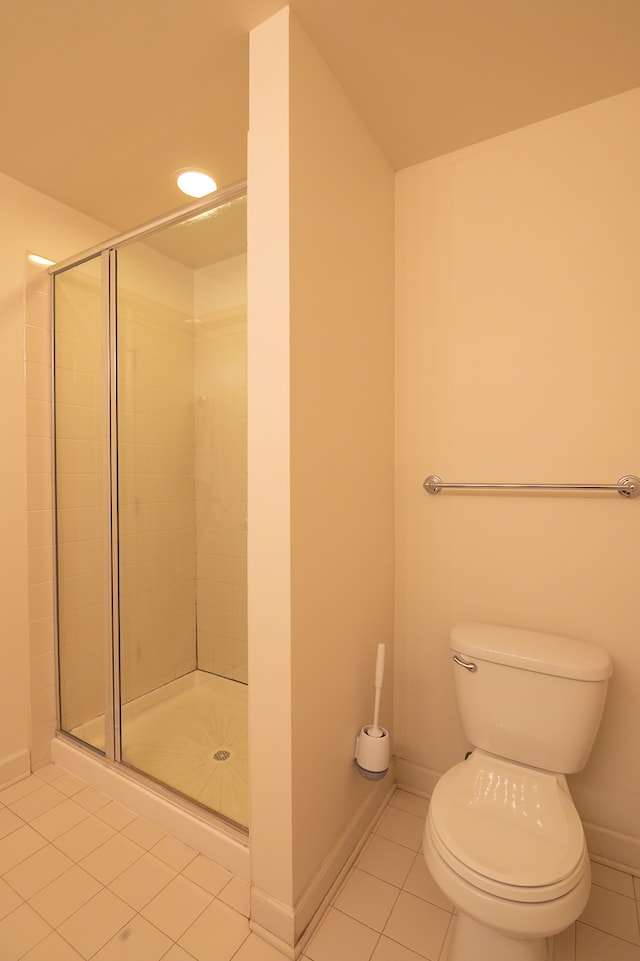 bathroom featuring tile patterned flooring, walk in shower, and toilet