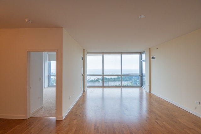 unfurnished room featuring hardwood / wood-style flooring and floor to ceiling windows