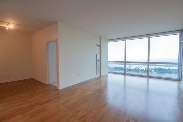 spare room featuring hardwood / wood-style floors and a wall of windows