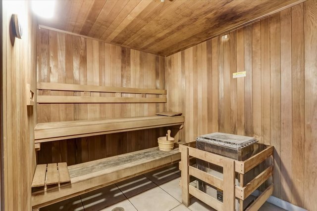 view of sauna / steam room featuring tile patterned flooring, wooden walls, and wooden ceiling