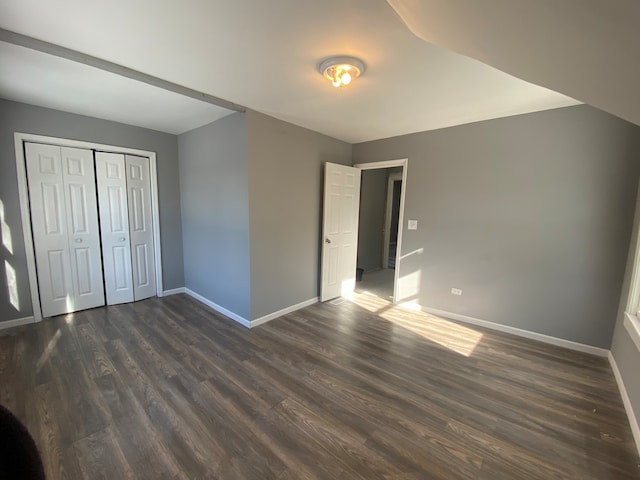 unfurnished bedroom with dark hardwood / wood-style floors and a closet