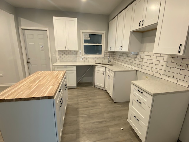 kitchen featuring backsplash, butcher block countertops, and white cabinets