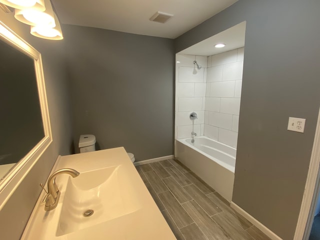 full bathroom with vanity, toilet, and tiled shower / bath combo