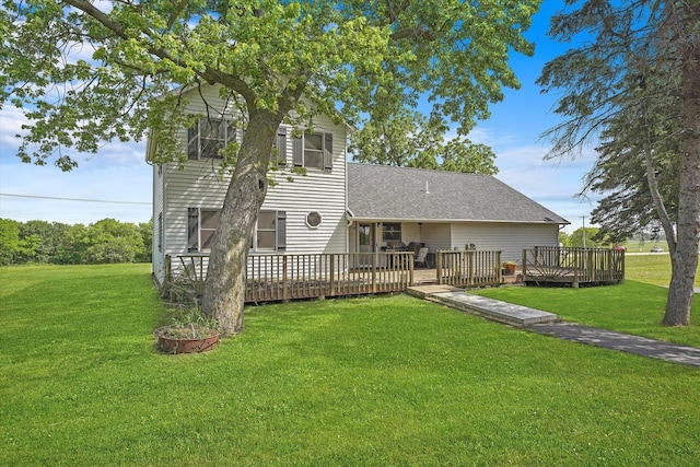 back of property featuring a yard, roof with shingles, and a wooden deck