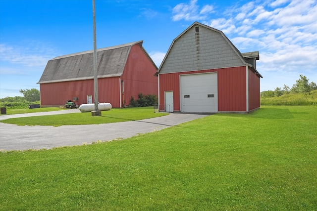 view of outbuilding with a garage and a lawn