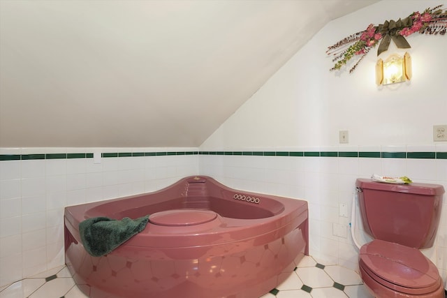 bathroom featuring tile patterned flooring, toilet, lofted ceiling, and tile walls