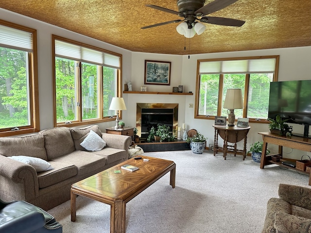 living room featuring carpet, ceiling fan, and a textured ceiling